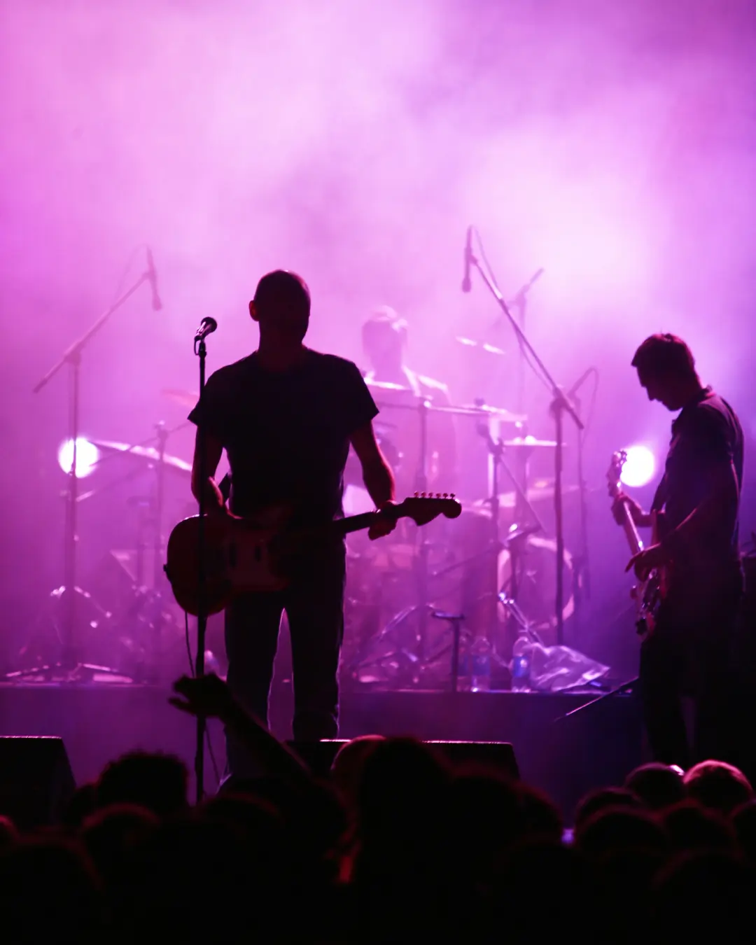 Grupo silhouette under magenta stage lights