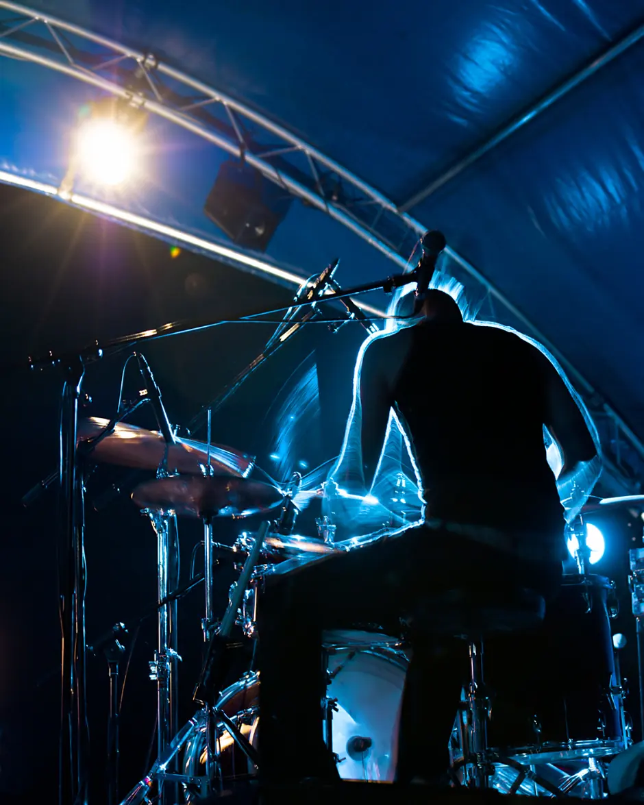 Drummer silhouette under blue stage light
